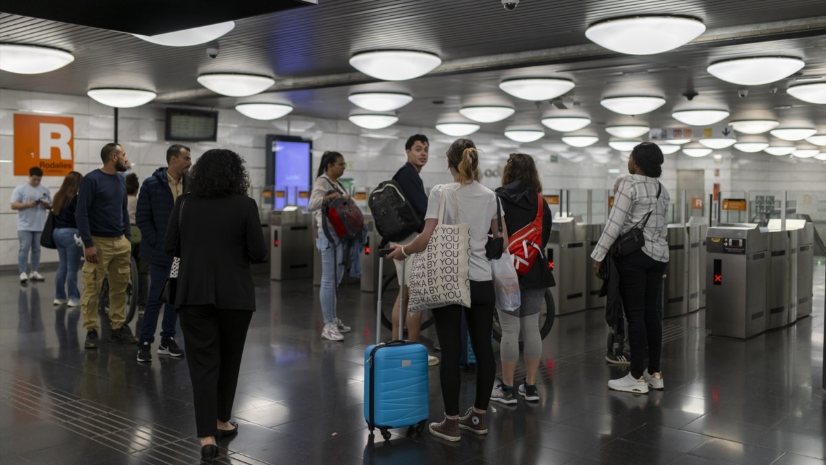 Varias personas esperan ayer en la estación de Renfe y Metro 'La Sagrera' en Barcelona