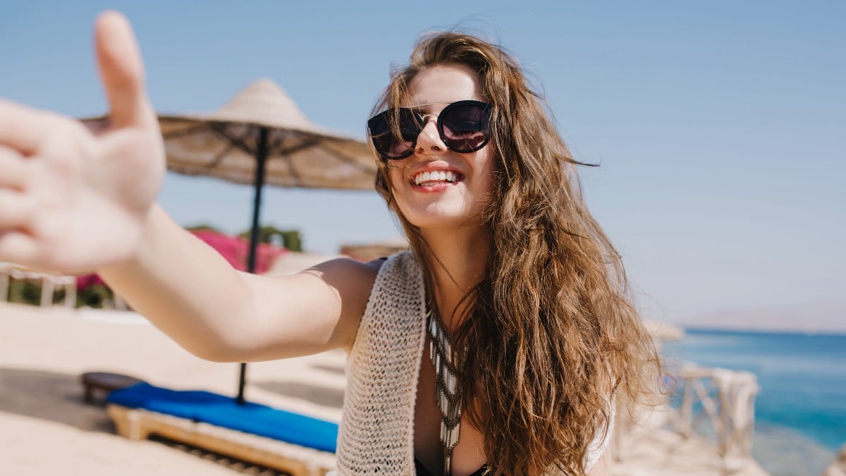Chica en una playa que ha podido disfrutar de su viaje gracia al Verano Joven 2024