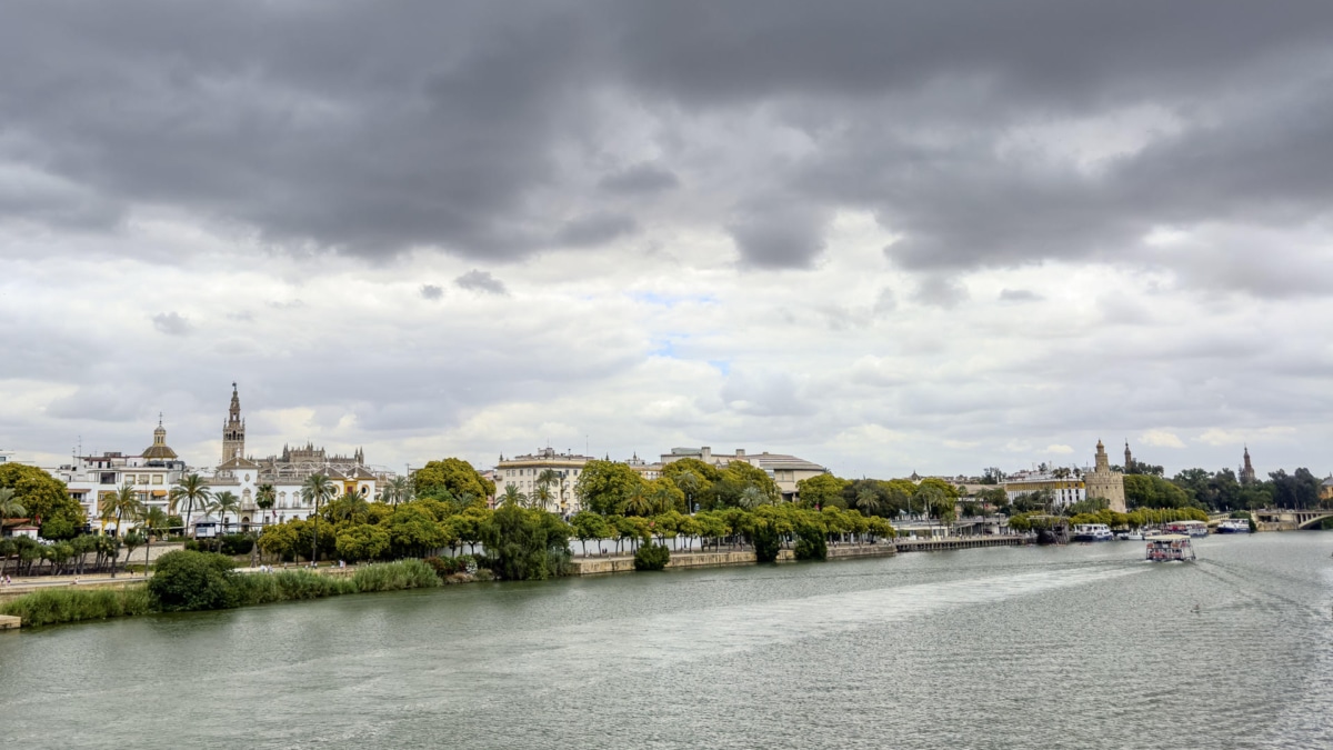 Vista del río Guadalquivir a su paso por Sevilla que amanecía este sábado cubierta de nubes y con una acusada bajada de temperaturas.