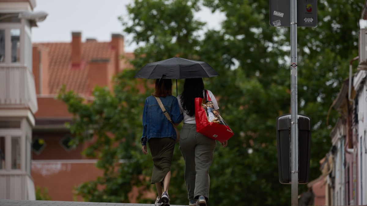 Dos mujeres se protegen de la lluvia con un paraguas, a 8 de junio de 2024