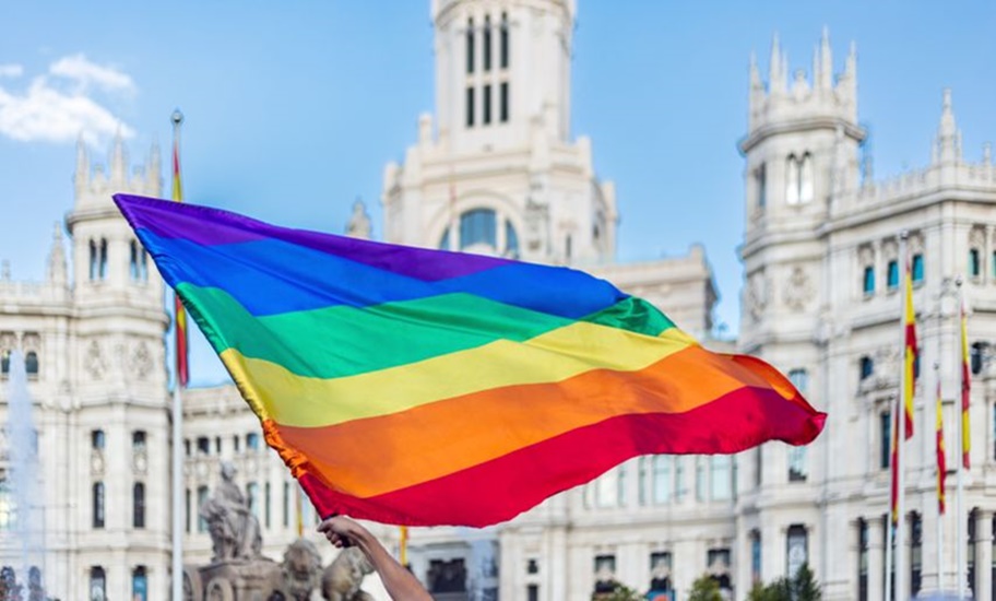 Brazos agitando la bandera LGTBIQ+ en la Plaza de Cibeles en Madrid Orgullo 2024