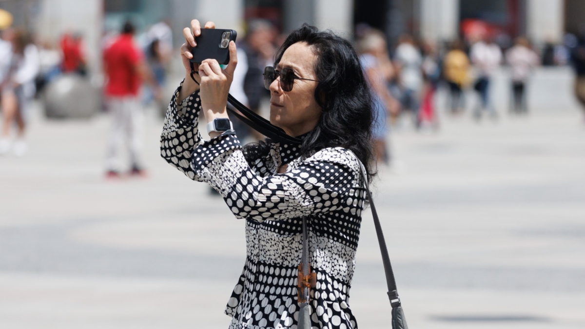 Una turista fotografía la Puerta del Sol.