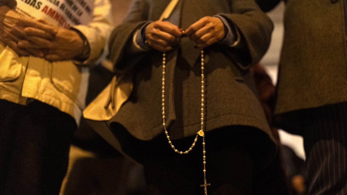 Una mujer con un rosario durante una manifestación contra la amnistía frente a la sede del PSOE en Ferraz