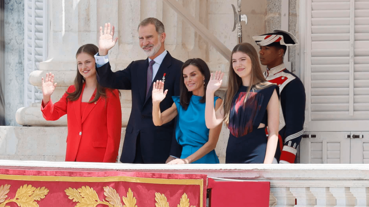 Los Reyes, acompañados por sus hijas Leonor y Sofía, saludan desde el balcón del Palacio Real.