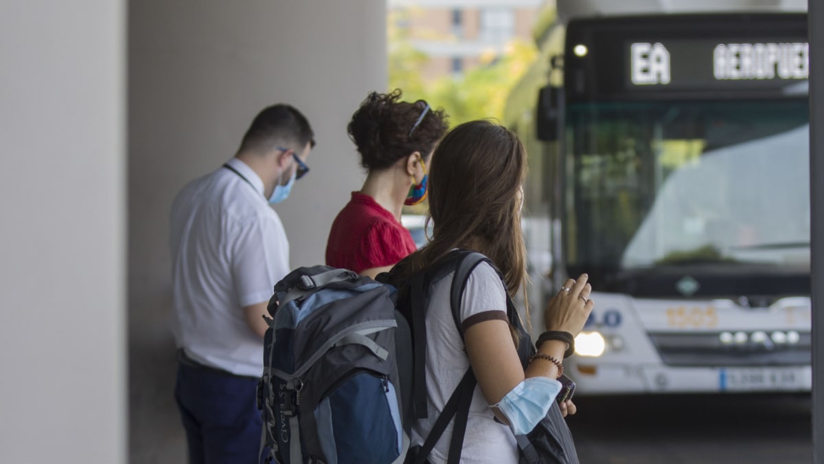 Varias personas en la parada del bus exprés hacia el aeropuerto. En Sevilla, (Andalucía, España)