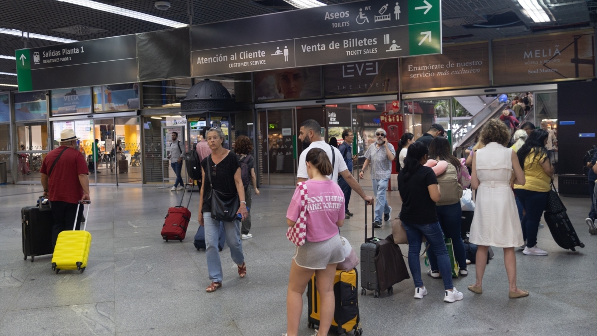 Varias personas en la estación de trenes Puerta de Atocha-Almudena Grandes