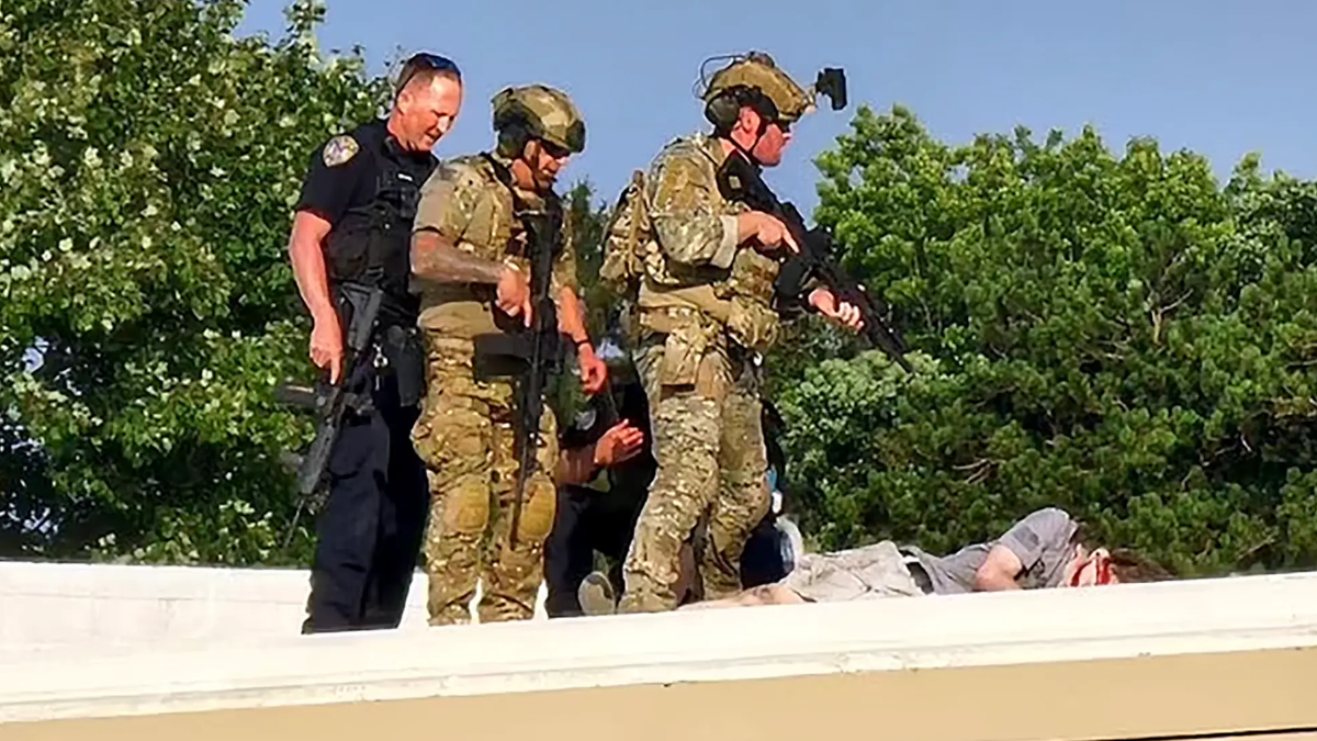 Varios agentes junto al cuerpo de Thomas Matthew Crooks en el tejado desde el que disparó a Trump.