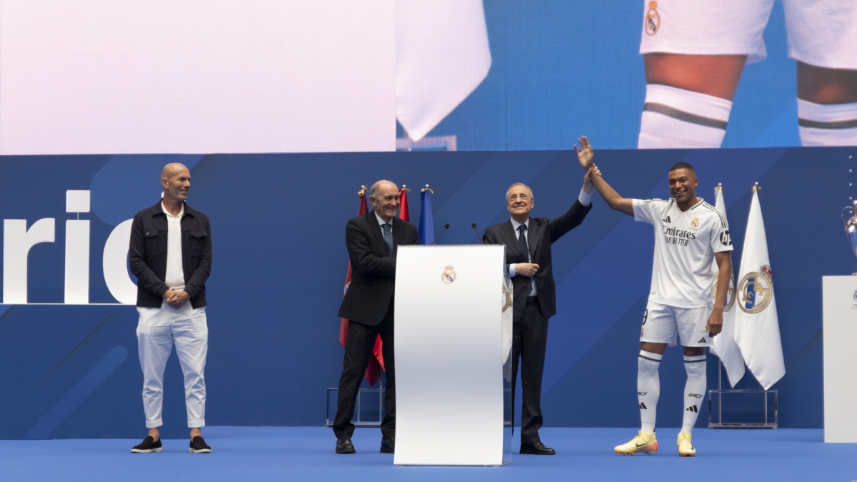 El presidente del Real Madrid, Florentino Pérez, levanta la mano a su nuevo fichaje, Kylian Mbappé