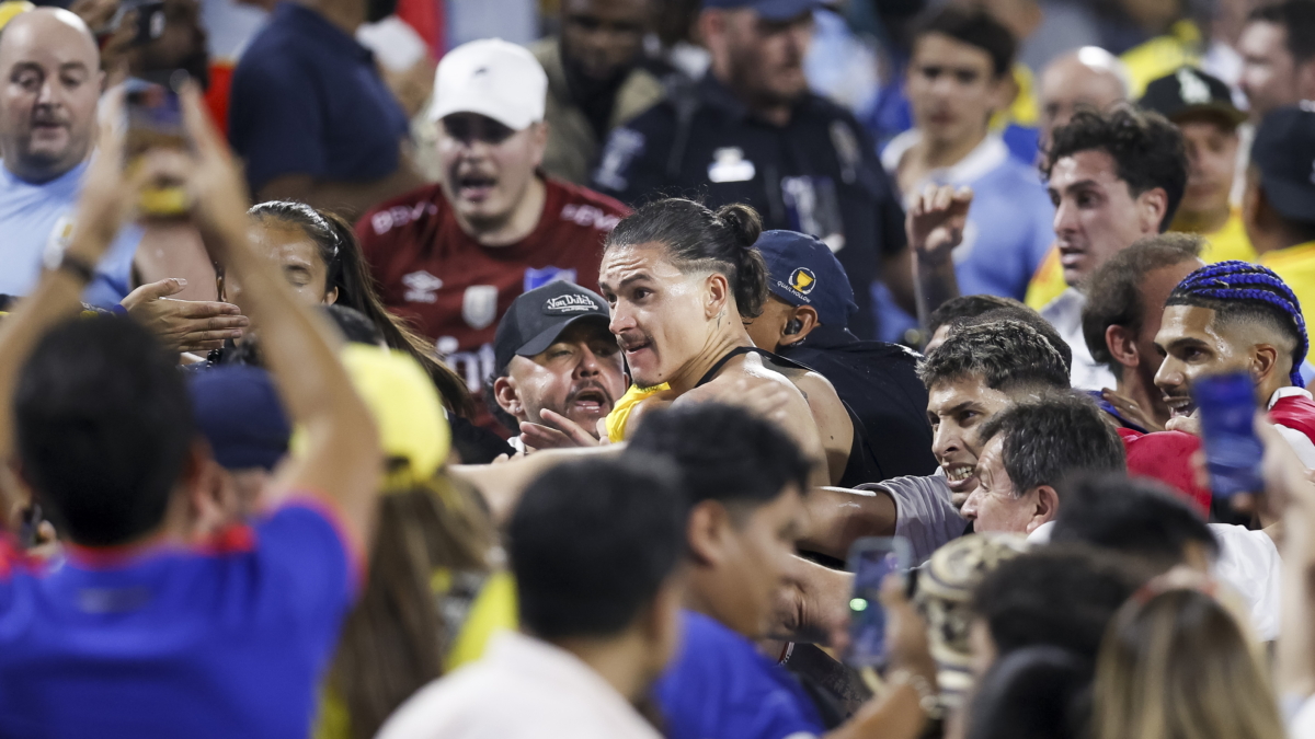 El futbolista de Uruguay Darwin Nunez salta a la grada para defender a su familia de un hincha colombiano