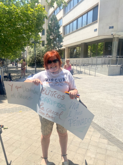 Una mujer sostiene carteles a las afueras del Juzgado