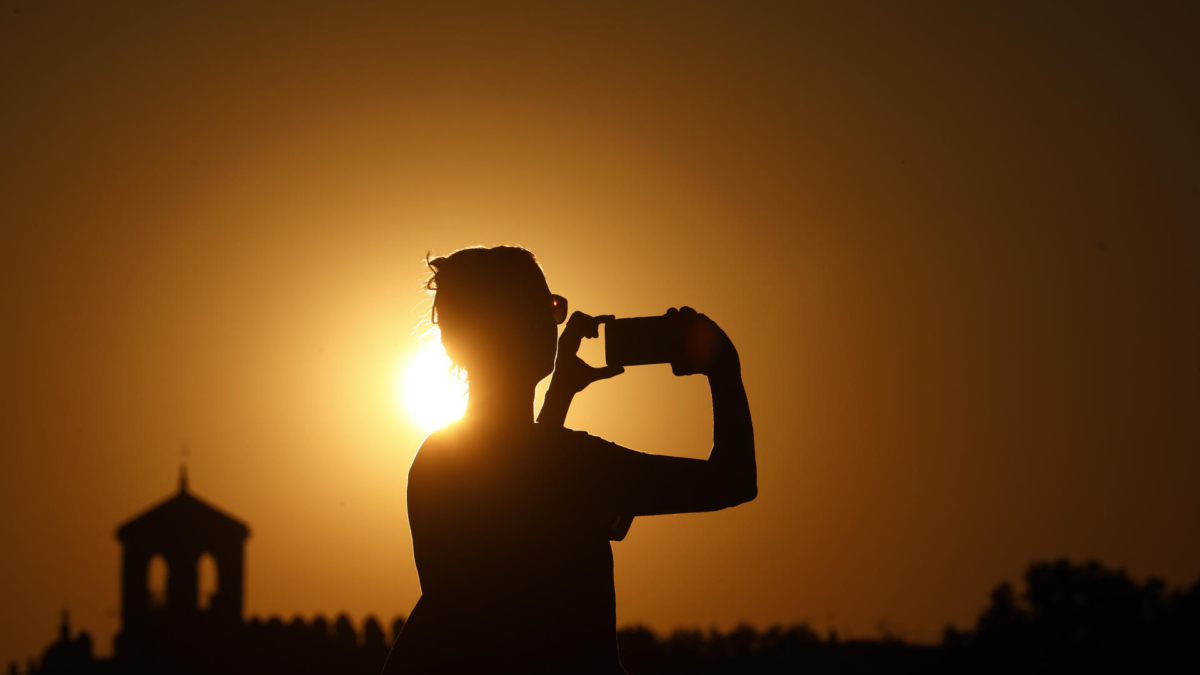 Una persona fotografía el atardecer en una jornada de altas temperaturas de 40 grados, el sábado en Códoba.