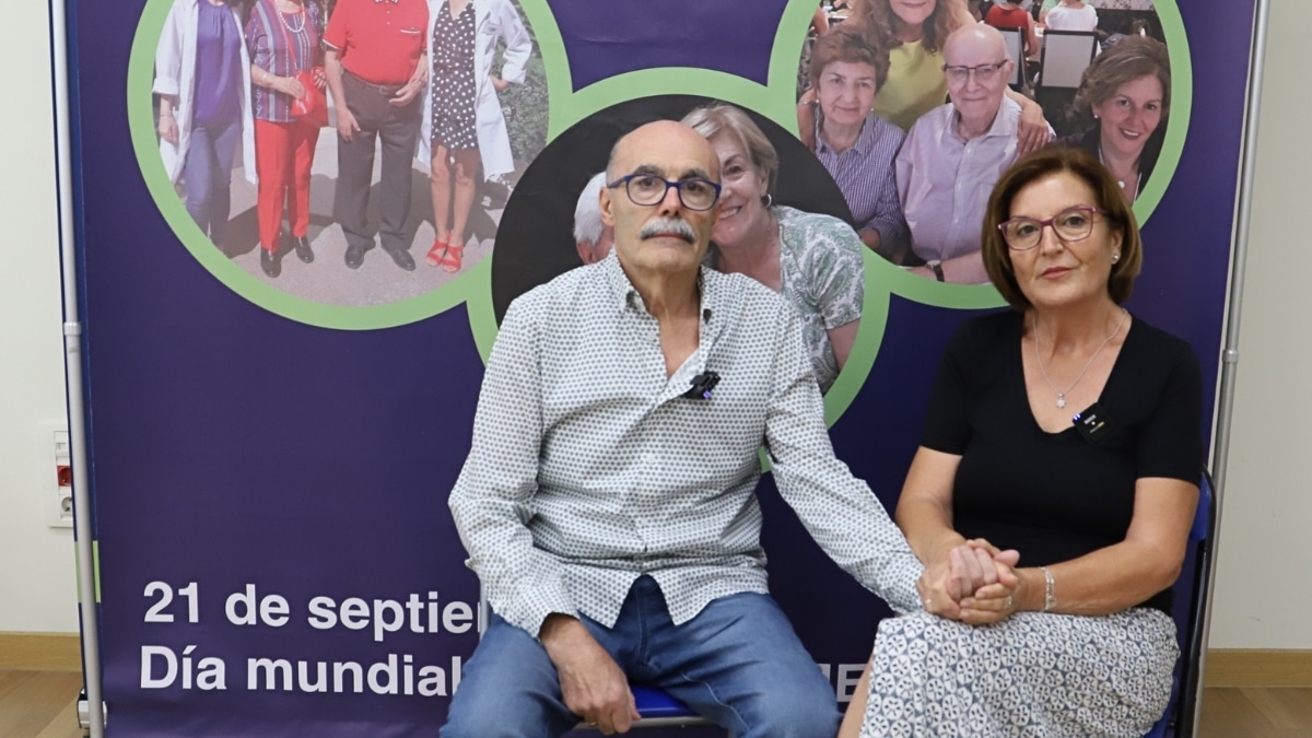 Damián Pavón, persona con Alzheimer, e Isabel López, su mujer y cuidadora, dándose la mano.