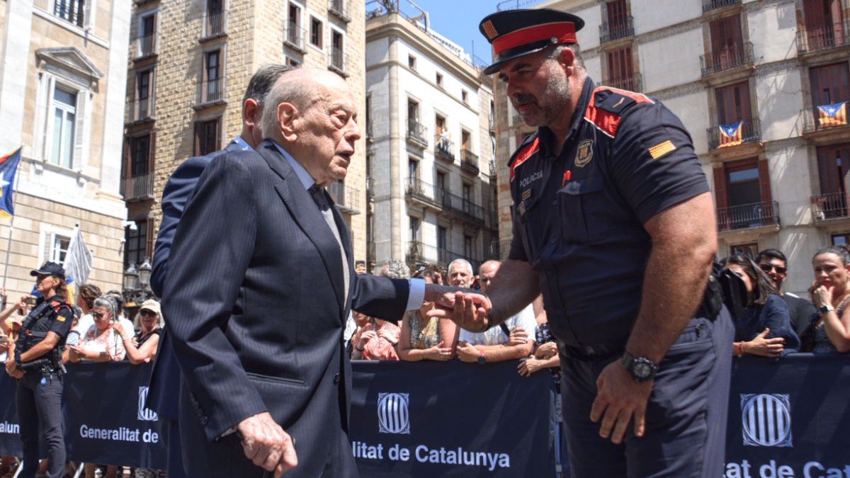 Jordi Pujol recibe el saludo de un mosso a la salida del Palau de la Generalitat tras la toma de posesión de Salvador Illa