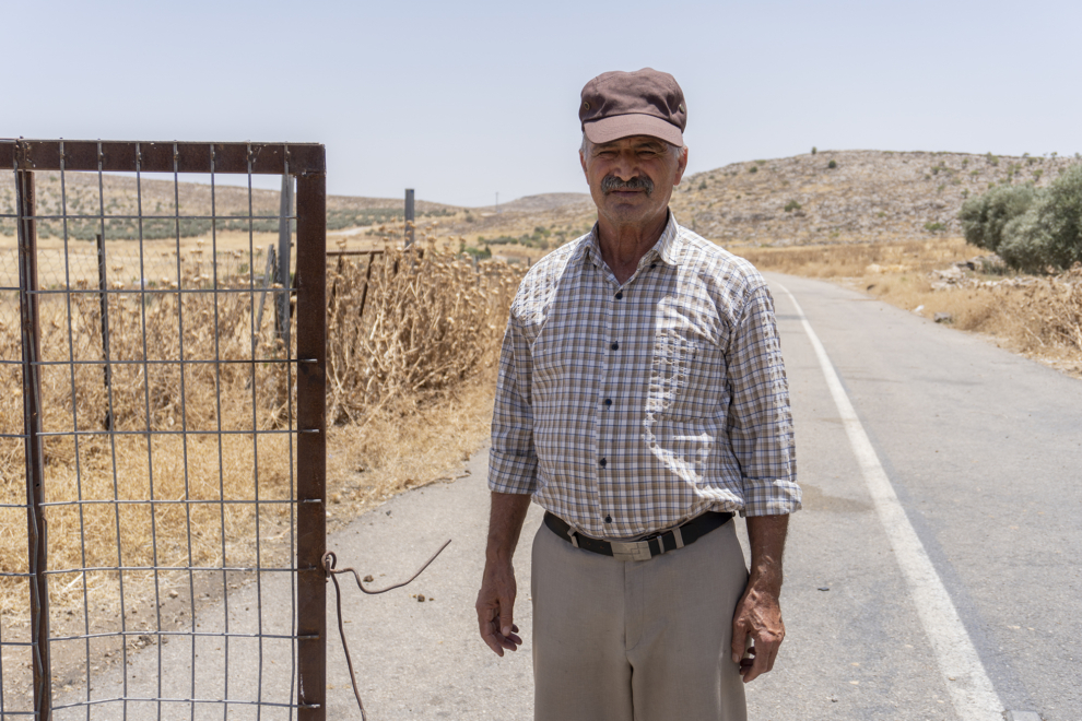 Abu Wahid Abu Naim, miembro del consejo local de la aldea palestina, en la verja que marca el límite que no pueden cruzar los vecinos.