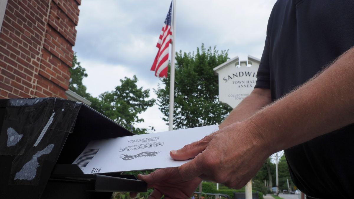 Un hombre introduce su voto por correo en un buzón en Sandwich, Estados Unidos.