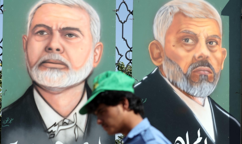 Un partidario de los hutíes pasa por dos retratos de Yehia Sinwar e Ismail Haniyeh en Saná.