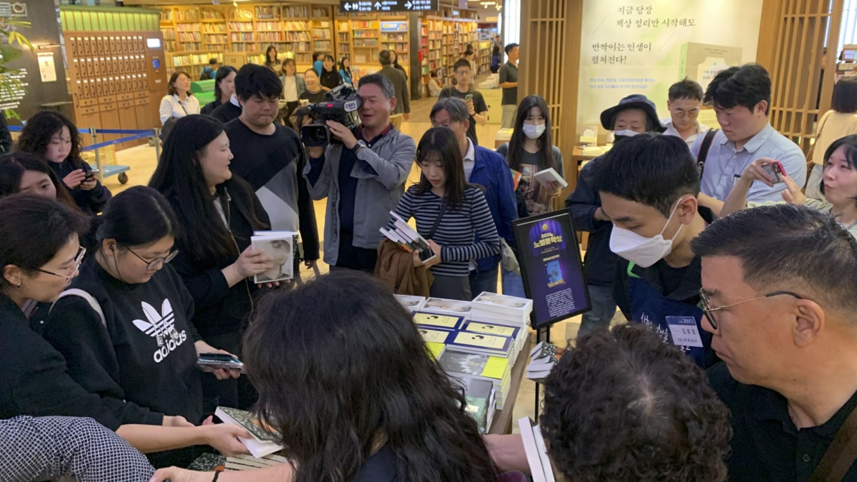 Clientes en la librería principal de la cadena Kyobo, en el distrito de Jongno en Seúl, se agolpan para hacerse con copias de libros de la escritora Han Kang un día después de que la autora fuera galardonada con el premio Nobel de Literatura