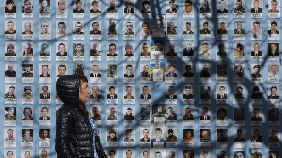 Una mujer pasa por el muro dedicado a los defensores de Ucrania caídos, en Kiev.