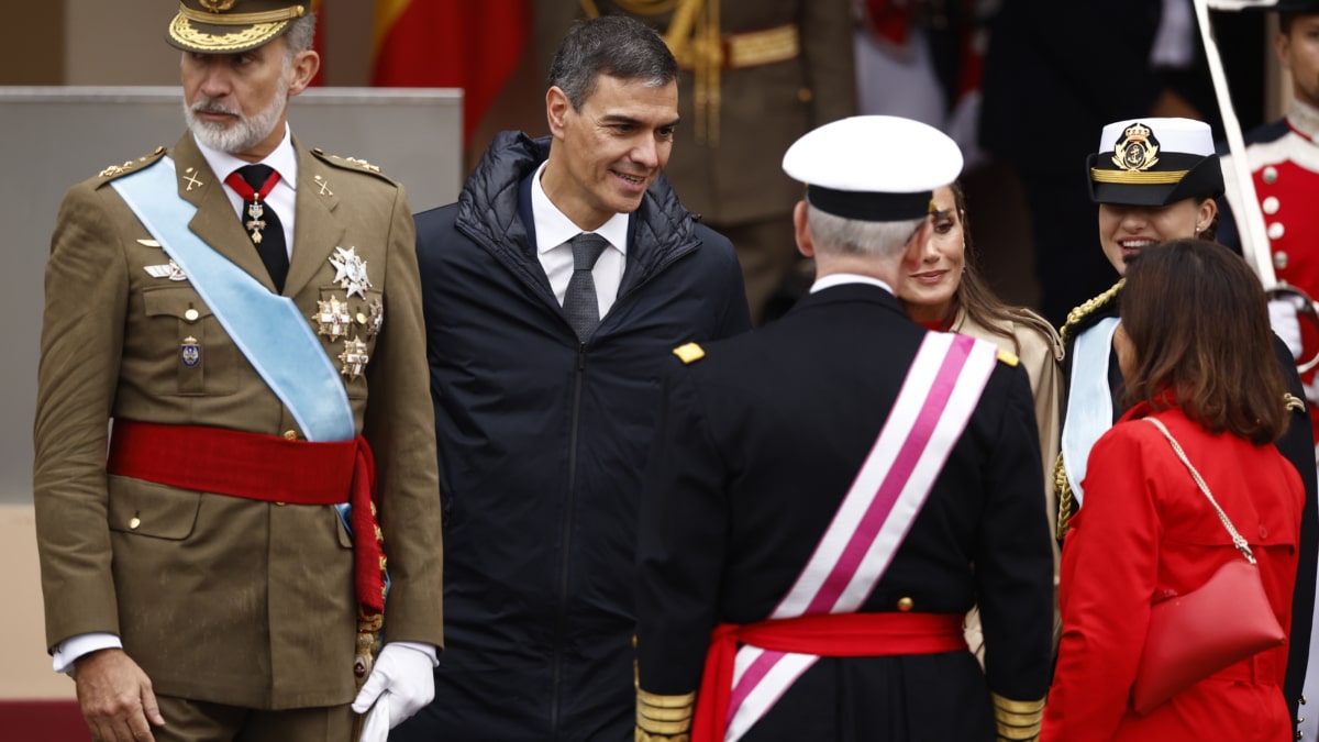 MADRID, 12/10/2024.- Los reyes de España, Felipe VI y Letizia, acompañados por la princesa de Asturias, Leonor de Borbón, conversan con el presidente del Gobierno, Pedro Sánchez (2i), la ministra de Defensa, Margarita Robles (d, de espaldas), y con el jefe del Estado Mayor de la Defensa, Teodoro Esteban López Calderón (2d, de espaldas), este sábado, en el marco del tradicional desfile del Día de la Fiesta Nacional por el Paseo del Prado de Madrid. Un total de 4.092 efectivos de las Fuerzas Armadas, de los cuales 473 son mujeres, 85 aeronaves, 266 vehículos motorizados y 210 caballos participarán en la parada militar. EFE/Daniel González