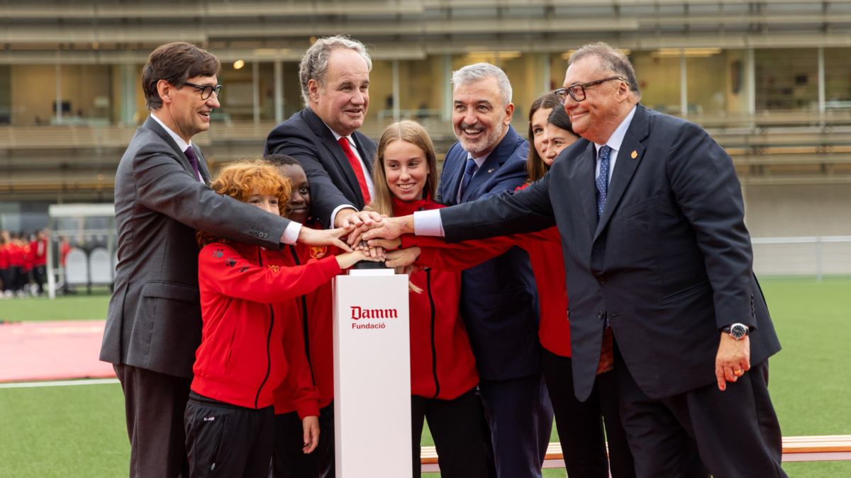 Salvador Illa, Demetrio Carceller Arce, Jaume Collboni y Ramon Agenjo junto a un grupo de jugadores y jugadoras de la Damm, en el momento de accionar el botón para descubrir la placa inaugural