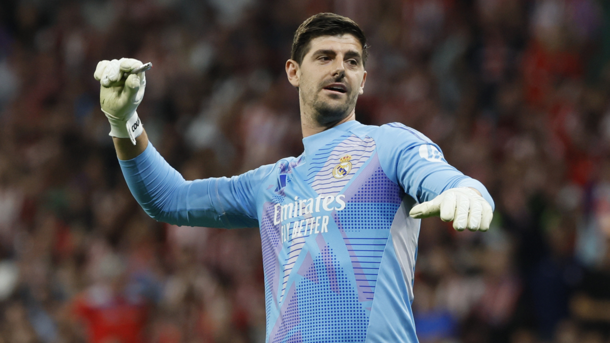 El portero del Real Madrid Thibaut Courtois retira un mechero lanzado desde la grada del estadio Metropolitano