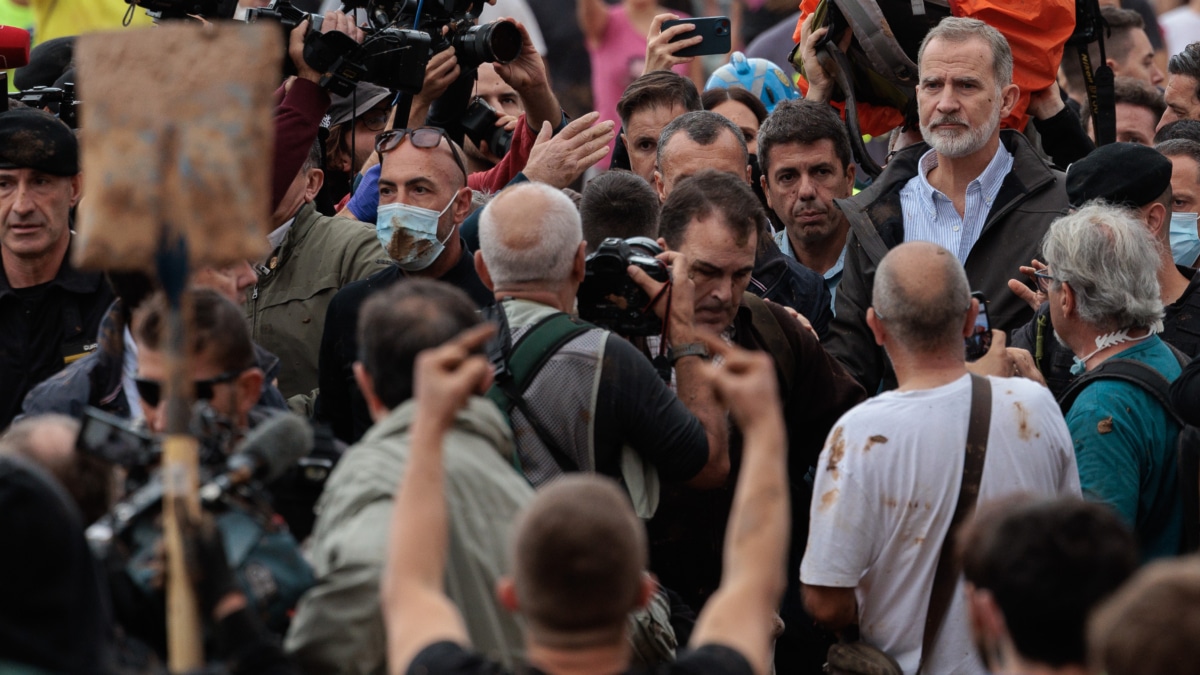 PAIPORTA (VALENCIA), 03/11/2024.- El rey Felipe, durante su visita a Paiporta este domingo. Gritos de 'fuera', así como lanzamiento de barro, están recibiendo a la comitiva de los reyes de España, el presidente del Gobierno, Pedro Sánchez, y el president de la Generalitat, Carlos Mazón, a su llegada al centro de Paiporta. Numerosas personas indignadas han recibido con insultos a la comitiva y se han encarado con ella, mientras que tanto el rey como la reina ha intentado mediar con jóvenes que se les han acercado. EFE/ Biel Aliño