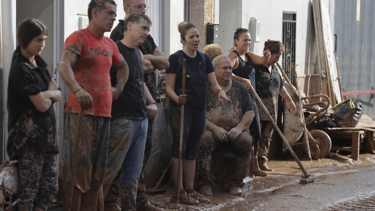 Vecinos de la Masía del Oliveral, en Riba-Roja (Valencia), cubiertos de barro por la limpieza del lodazal.