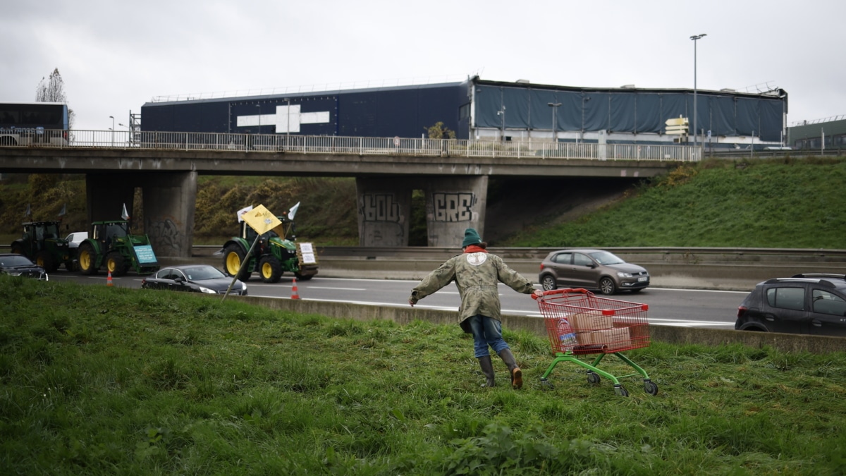 Un agricultor francés porta provisiones en un carro para los compañeros que bloquean la carretera N118 en Velizy Villacoublay, cerca de París