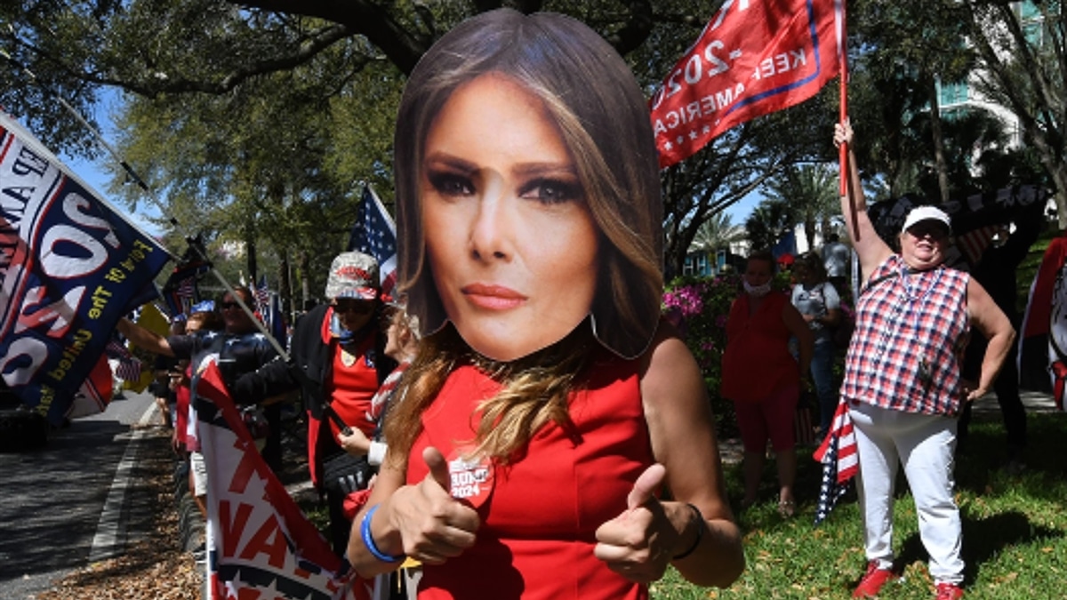 Una mujer luce una máscara de Melania Trump durante un rally en 2021.