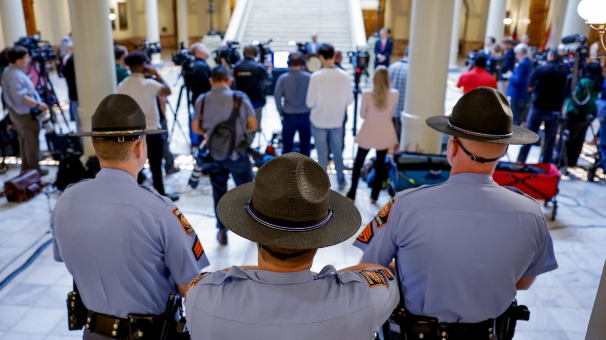 Tres agentes de la policía estatal de Georgia vigilan mientras el secretario de Estado de Georgia, Brad Raffensperger, da una rueda de prensa sobre el voto anticipado en Atlanta.