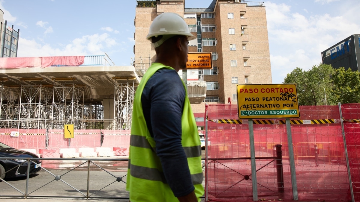 Un trabajador pasa por delante de una obra en Madrid, en una imagen de archivo.