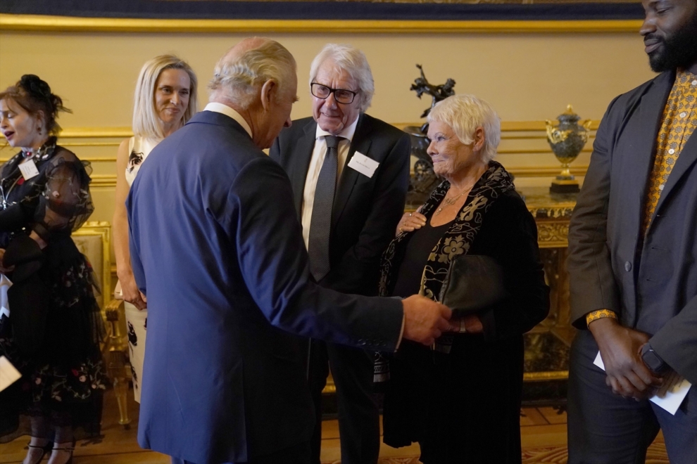 EL rey Carlos III habla con Judi Dench en una recepción en el castillo de Windsor.