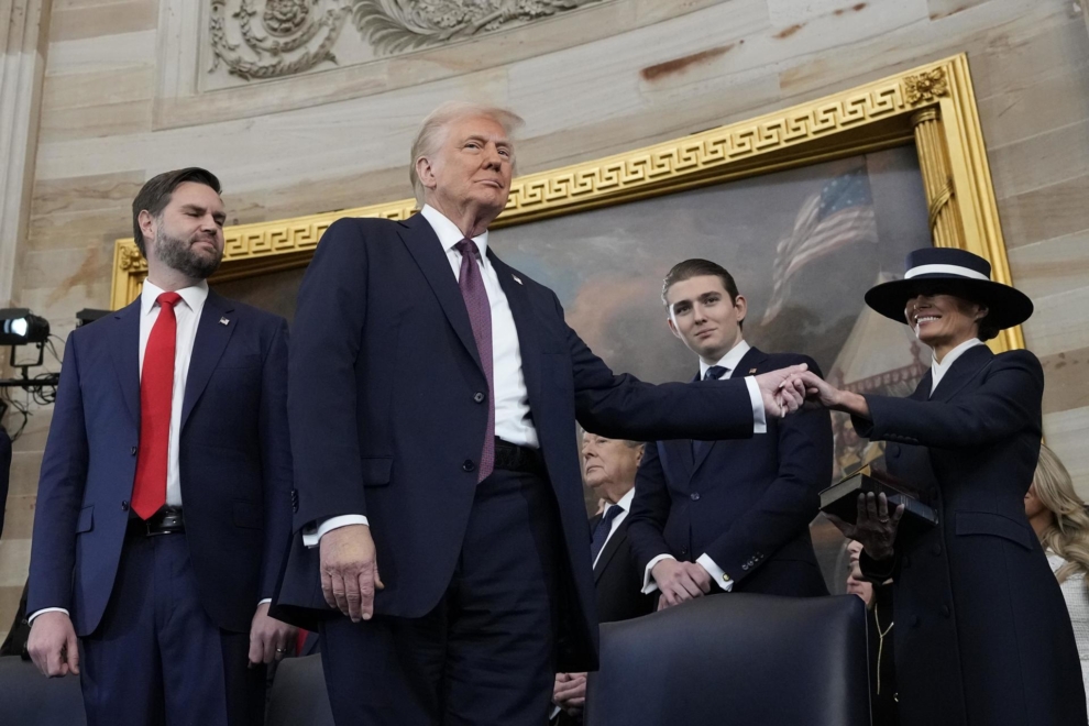 Donald Trump coge la mano de su mujer durante la inauguración de su mandato. A su lado están Barron Trump y JD Vance.