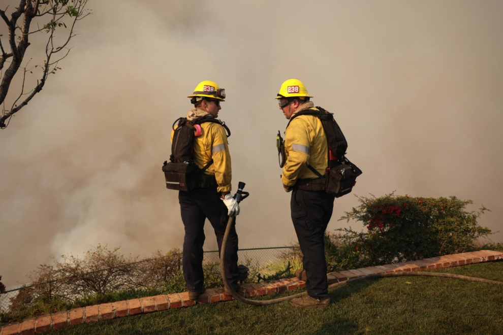 Bomberos trabajan en una estructura defensiva contra el incendio de Palisades en Los Ángeles, California.