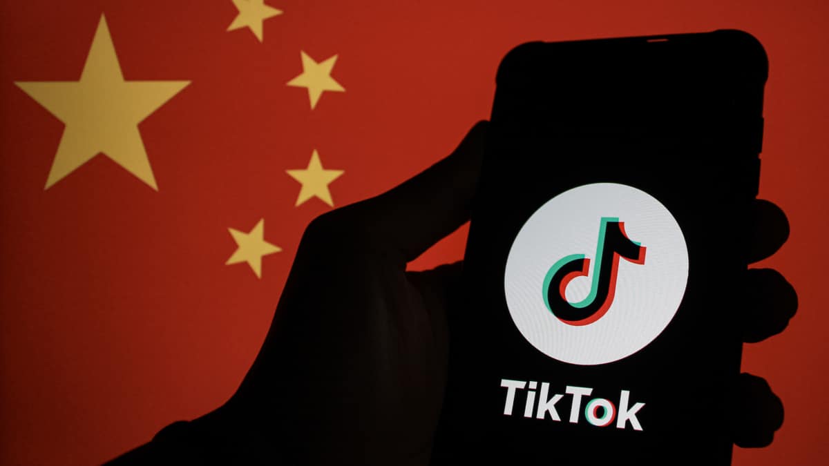 El logo de TikTok en un smartphone con la bandera de China de fondo