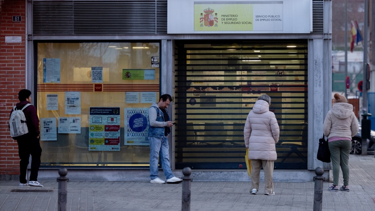 Varias personas en la puerta de una oficina del SEPE