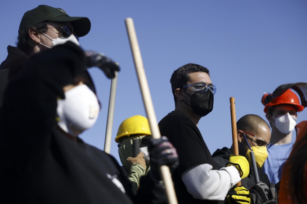 Voluntarios se reúnen antes de empezar a limpiar escombros en Altadena, California.