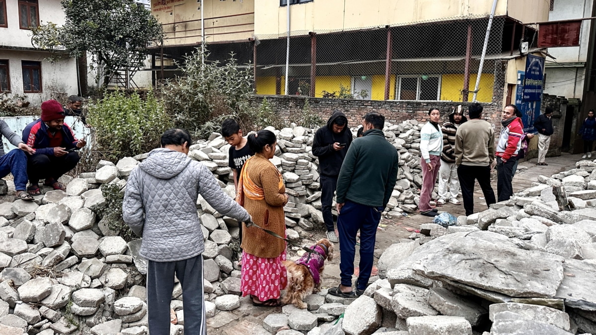 Los nepaleses se reúnen después de salir de sus hogares tras un terremoto temprano en la mañana en Katmandú