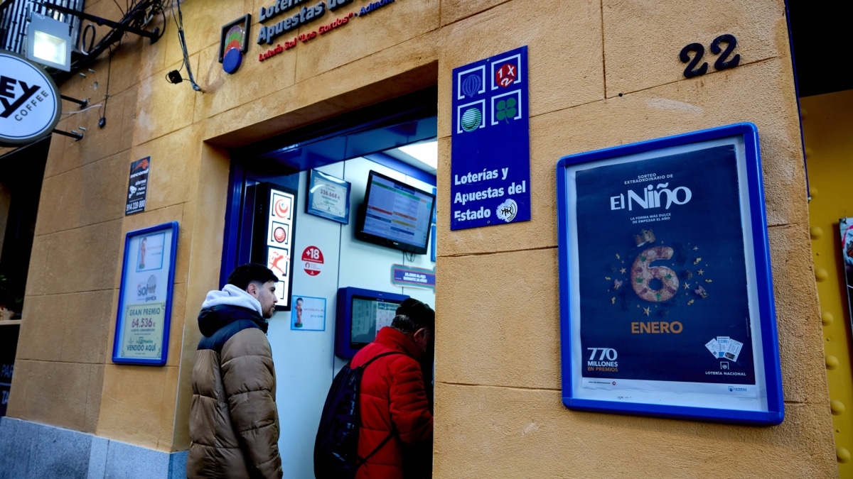 Varias personas hacen cola en una administración de lotería para comprar décimos de cara al Sorteo de El Niño