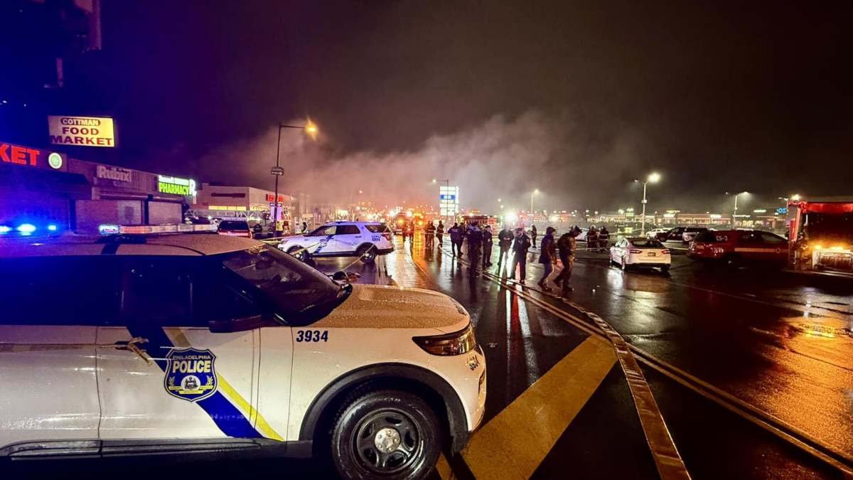 Agentes de policía en el lugar donde un avión se estrelló en la noche del viernes en las inmediaciones del centro comercial Roosevelt en la Avenida Cottman en Filadelfia, Estados Unidos.