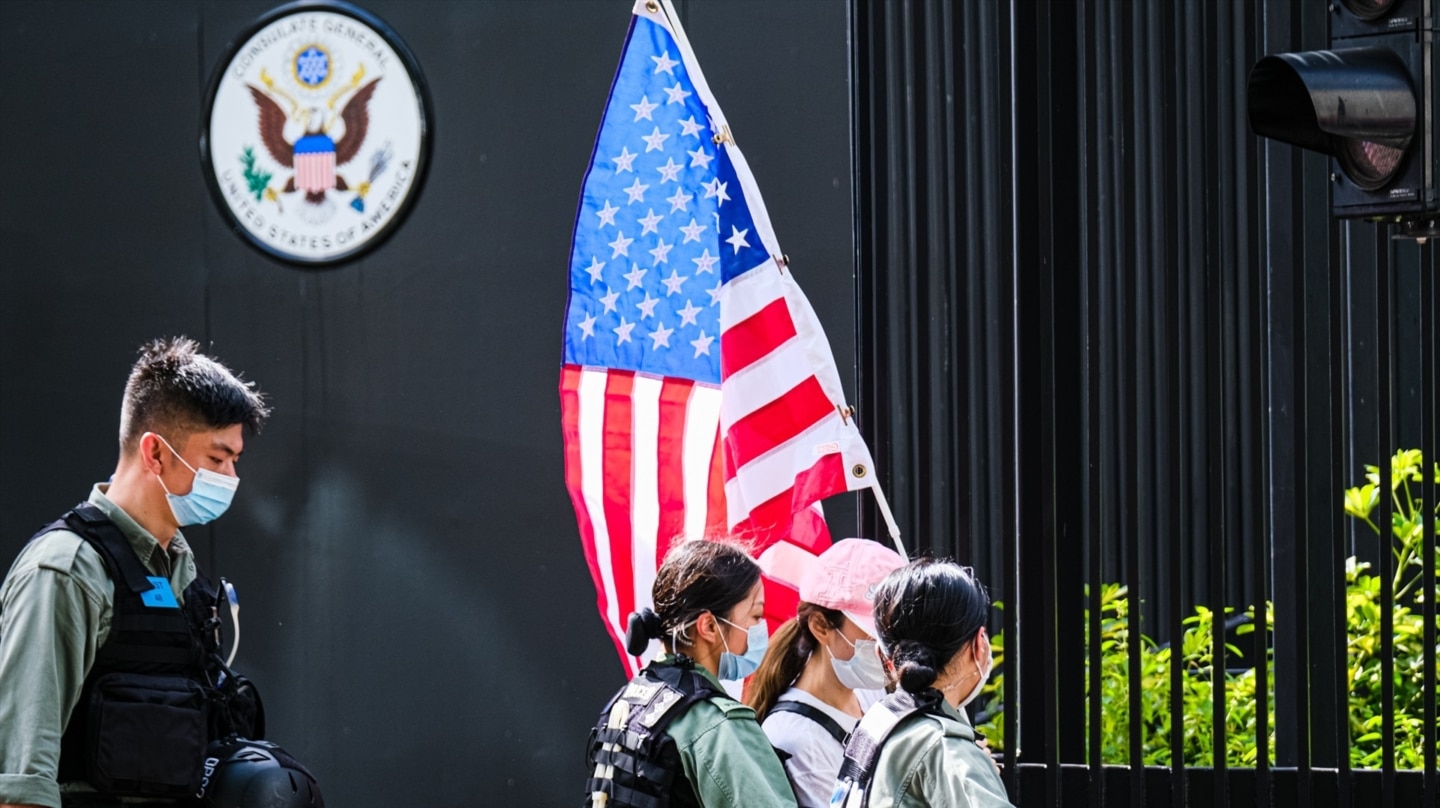 Imagen de archivo de policías chinas escoltando a una mujer que lleva una bandera estadounidense a las afueras del consulado estadounidense en Hong Kong, China.