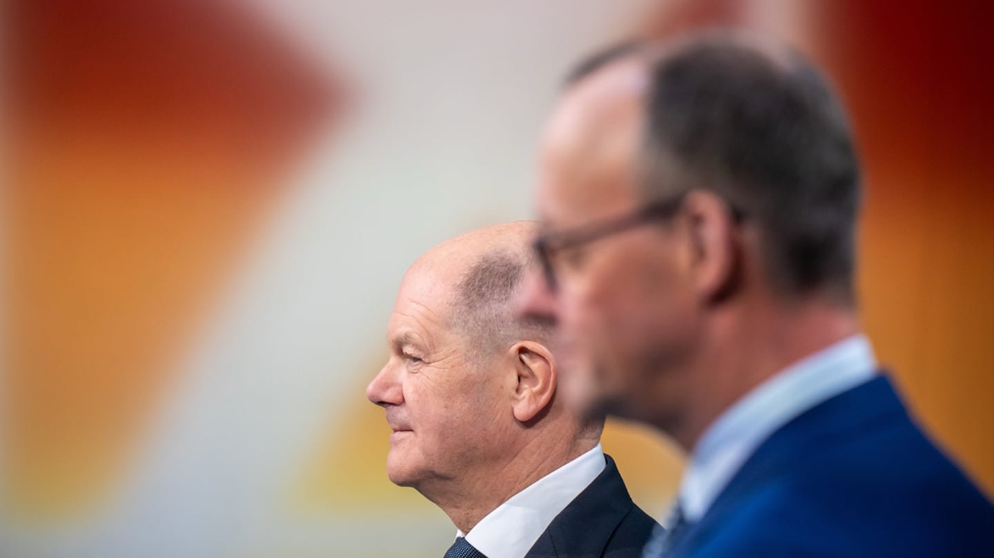 El canciller Olaf Scholz, en segundo plano, y el candidato de la Unión a la cancillería, Friedrich Merz, en Berlín.