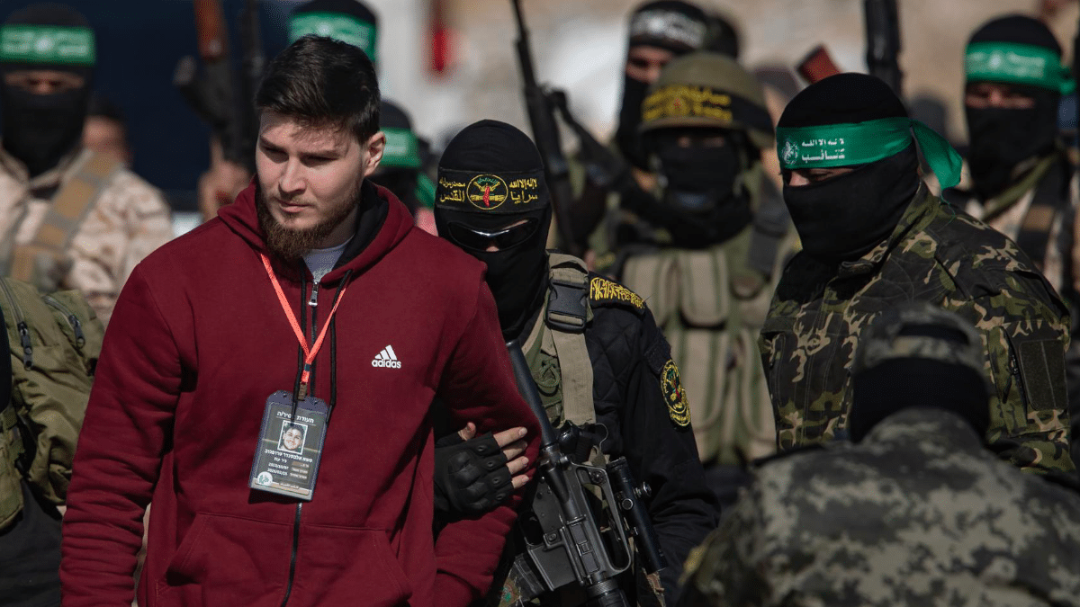 Milicianos de Hamás conducen a Alexander Troufanov antes de su liberación este sábado en Jan Yunis.