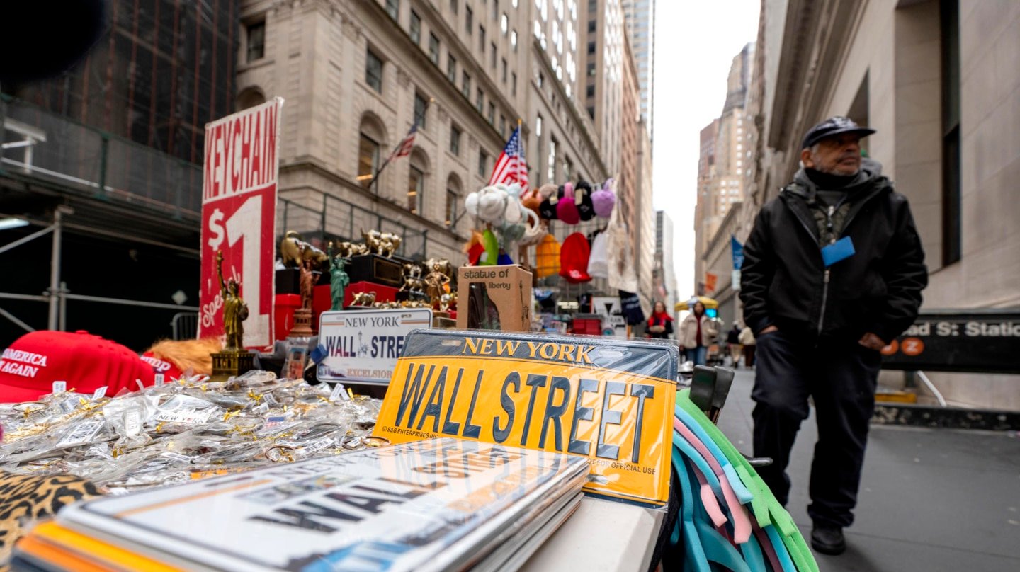 Un vendedor ambulante promociona productos alusivos a Wall Street frente a la bolsa de valores de Nueva York este martes, en Nueva York.