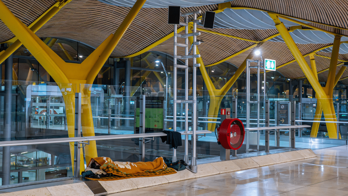 Una persona duerme la pasada madrugada en la Terminal 4 del Aeropuerto de Barajas.