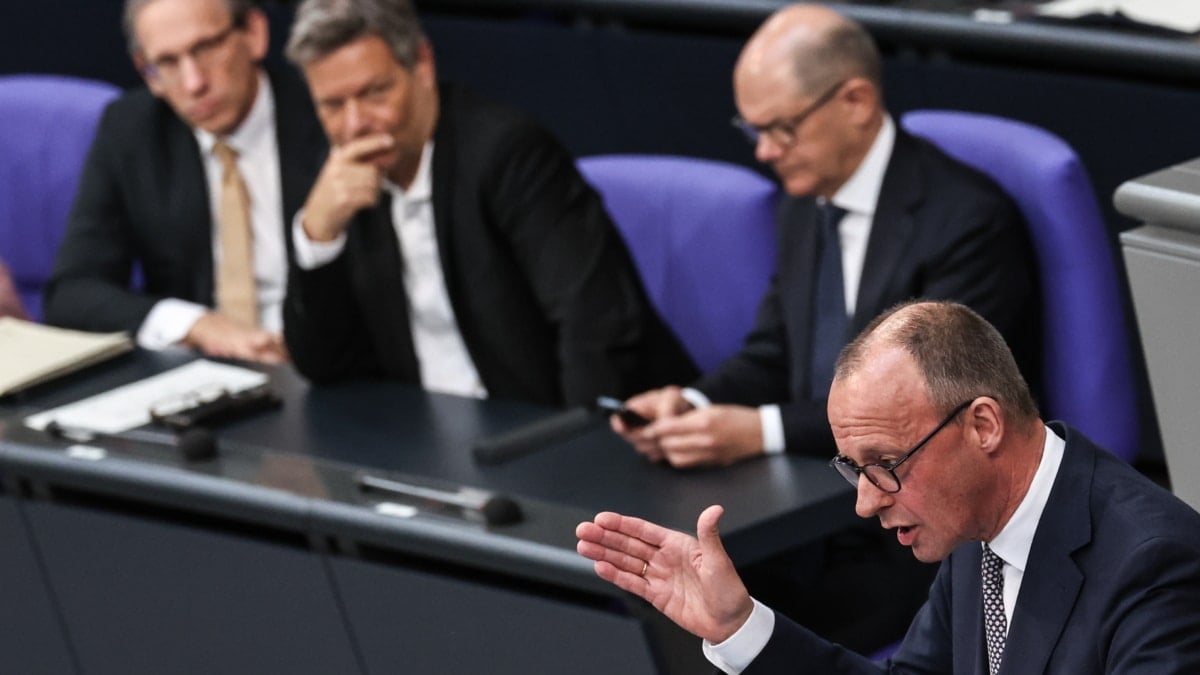 El futuro canciller, Friedrich Merz, (d) habla mientras le observa el actual canciller, Olaf Scholz, en el Bundestag.