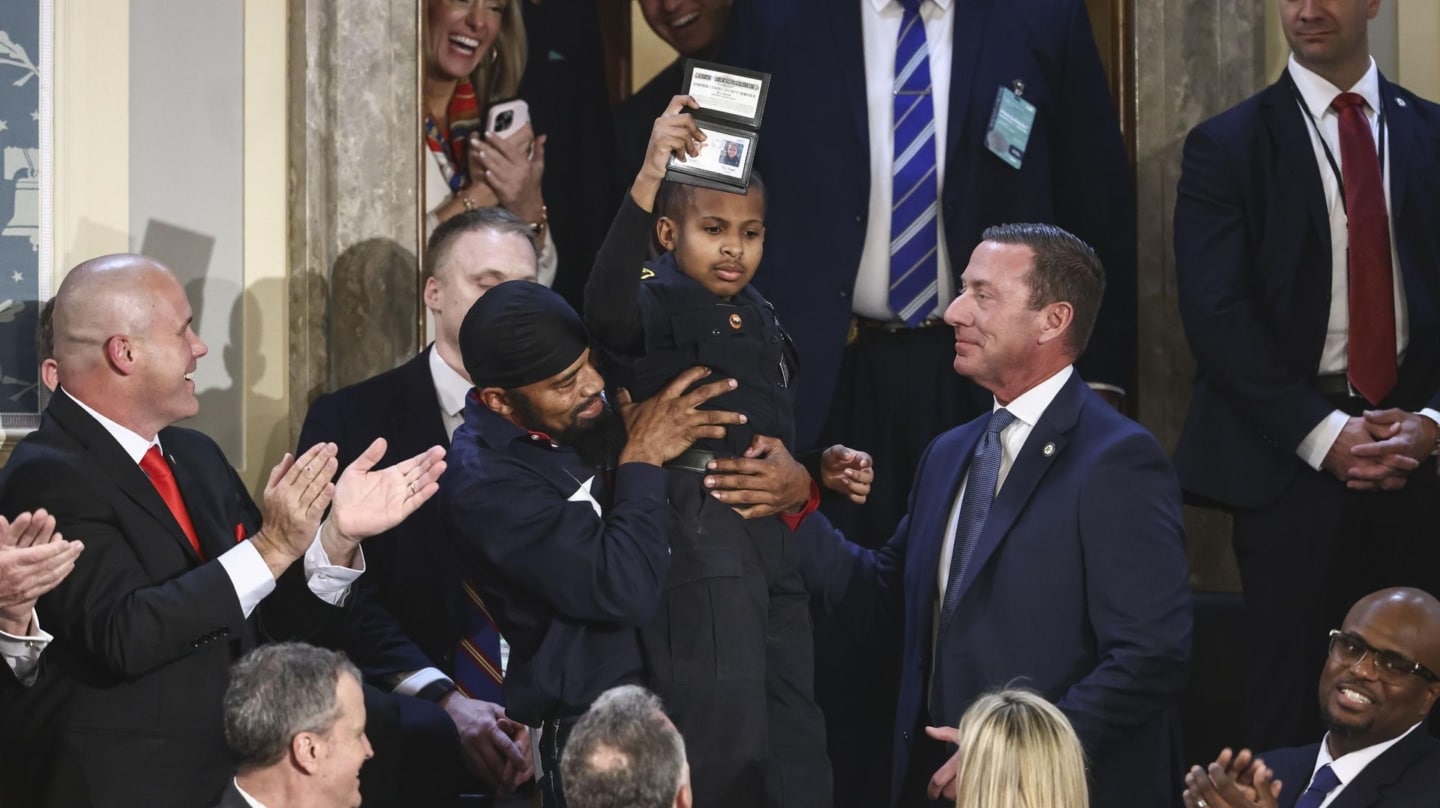 Devarjaye DJ Daniel, un niño de 13 años superviviente de cáncer, enseña el carné simbólico del Servicio Secreto que Trump le ha regalado durante su primer discurso ante el Congreso.