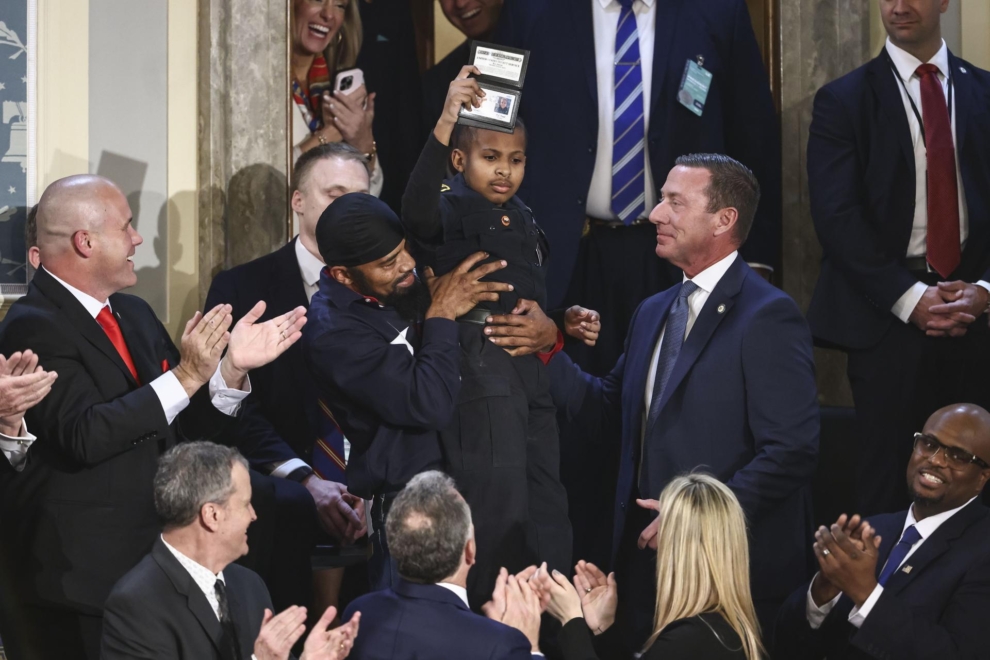 Devarjaye DJ Daniel, un niño de 13 años superviviente de cáncer, enseña el carné simbólico del Servicio Secreto que Trump le ha regalado durante su primer discurso ante el Congreso.